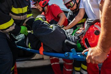 Firefighter and ambulance workers taking care of other firefighter and pulling him from crashed car. © Dusan Petkovic