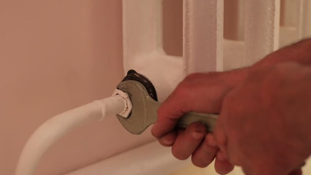 Wrench tightens the nut on the radiators