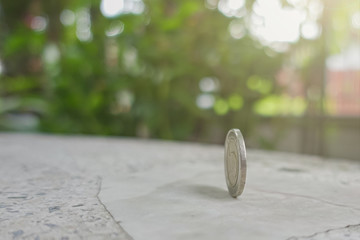 coins always have 2 side idiom idea concept, a Thai coin rolling on table with blurred background...