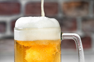 Close up Serving a refreshing beer mug with foam on a white bar