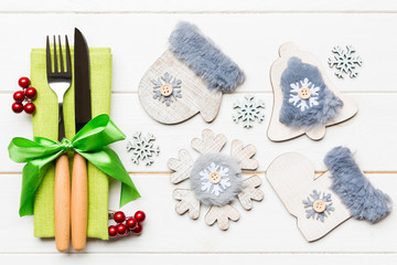 Top view of New Year dinner on wooden background. Festive cutlery on napkin with christmas decorations and toys. Close up of family holiday concept