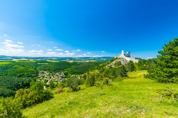 Fototapeta na wymiar The old ruins of castle Cachtice (Čachtice in local speak). Ruined castle on top of hill at Slovakia. Famous and mysterious place known from legend of blood lady Bathory. Summer day, panorama view.