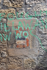 Detail of Small Blocked Window in Rough Textured Stone Wall with Spray Paint 