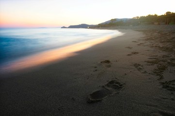 Beautiful mediterranean coast in sunset with fingerprints in sand.