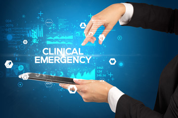 Close-up of a touchscreen with CLINICAL EMERGENCY inscription, medical concept