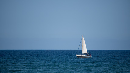 Fototapeta na wymiar Small sailboat in the middle of the ocean