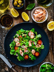 Salmon salad - roasted salmon and vegetables on wooden background
