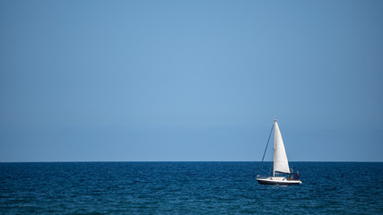 Small sailboat in the middle of the ocean