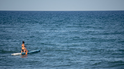 Mujer surfeando en el océano en un día soleado