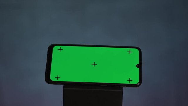 Online shopping concept. Smartphone green screen with traking points with green credit card with tracking dots moving camera on black background.