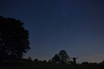 A man with a headlamp looks at the starry sky.