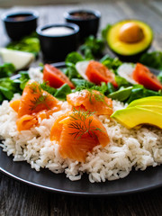 Salmon salad - smoked salmon white rice and vegetables on wooden table