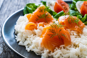 Salmon salad - smoked salmon white rice and vegetables on wooden table