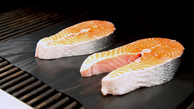 Fish salmon cuts being grilled in garden 