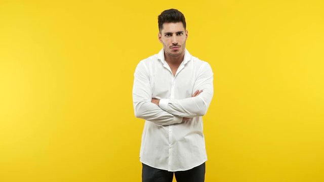 Young handsome man looking straight ahead, serious face, arms crossed, concept of goal and a purpose