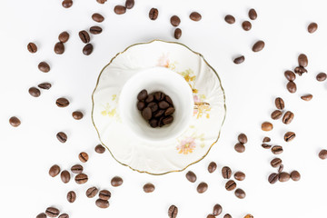Cup of coffee or porcelain tea on white background with coffee beans seen from above