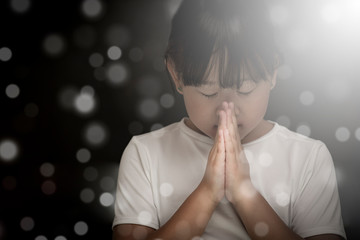 Asian face Child praying and worship to GOD Using hands to pray in religious beliefs and worship...