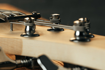 Guitar headstock with tuners on dark background