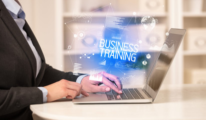 Side view of a business person working on laptop with BUSINESS TRAINING inscription, modern business concept