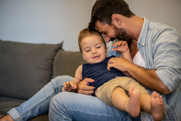 Father and son sit in the living room and spend time together