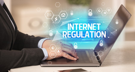 INTERNET REGULATION inscription on laptop, internet security and data protection concept, blockchain and cybersecurity
