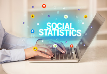 Freelance woman using laptop with SOCIAL STATISTICS inscription, Social media concept