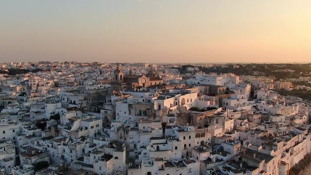 aerial shot of ostuni old town at sunset dusk drone fly backwards apulia italy