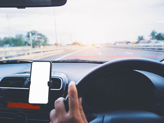 Blank empty screen smartphone on holder in car use for Navigation or GPS. Car interior view.