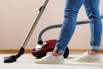 Fototapeta premium Close up of a woman vacuum-cleaning the carpet