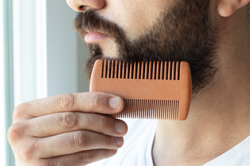 Bearded man comb his beard - obrazy, fototapety, plakaty