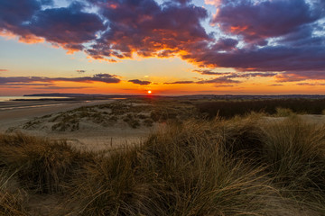 The sun setting over the high weald of east Sussex from the dunes of Camber Sands one beautiful March evening.