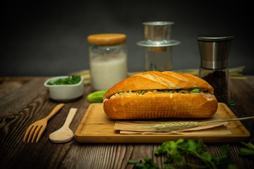 Snack at break time. Famous Vietnamese food is Banh mi thit and black coffee, popular street food from bread stuffed with raw material: pork, ham, pate, egg and fresh herbs.Typical Vietnamese sandwich
