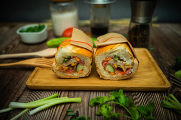 Snack at break time. Famous Vietnamese food is Banh mi thit and black coffee, popular street food from bread stuffed with raw material: pork, ham, pate, egg and fresh herbs.Typical Vietnamese sandwich