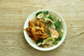 fried rice large noodles black soy sauce dressing mixed seafood and meat with Chinese kale in gravy sauce on plate