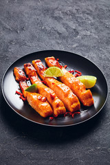 teriyaki salmon fillet on a black plate