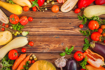 Frame of different vegetables around wooden table background. Autumn harvest. Free copy space in the center, top view