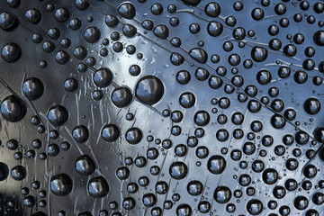 Silver metal spheres are located on the relief gray-blue metal background. Cosmic abstraction. 