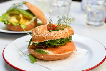 Salmon bagel on white plate. top view