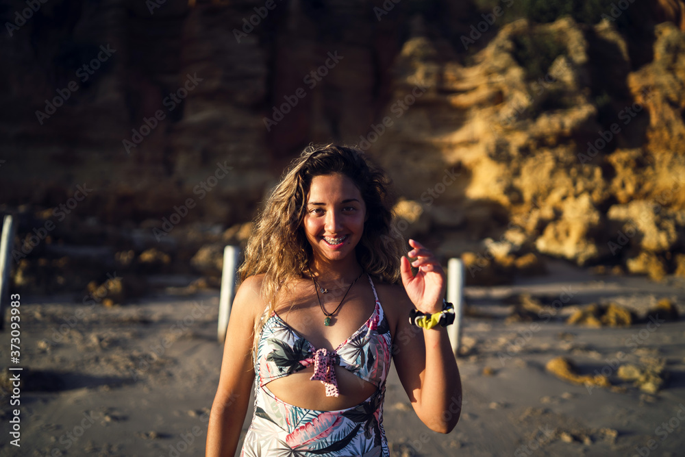 Poster Beautiful female posing in a swimsuit on background of a cliff