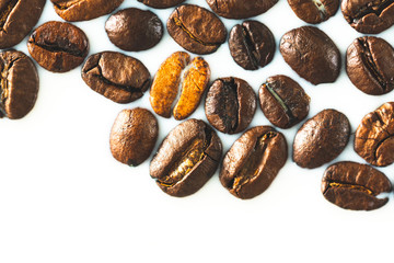 Roasted coffee beans on white milk background. Coffee beans in milk. Top view macro shot of arabica, robusta and iberica coffee seeds. 