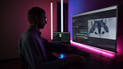 The man makes video editing. Video production. Color Correction. Sound editing. Film making. The...