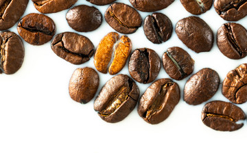 Roasted coffee beans on white milk background. Coffee beans in milk. Top view macro shot of...