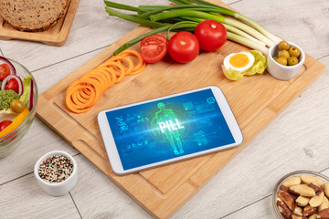 PILL concept in tablet with fruits, top view