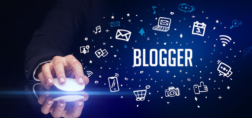 hand holding wireless peripheral with BLOGGER inscription, social media concept