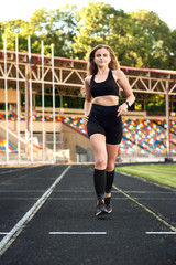 Fototapeta na wymiar young, athletic girl running on the track