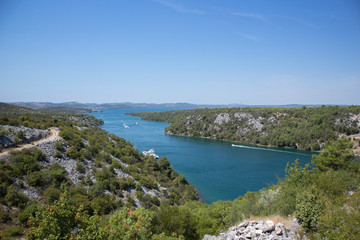 Fototapeta na wymiar Beautiful Skradin bay and Krka river going into Adriatic sea, surrounded by steep cliffs and green vegetation