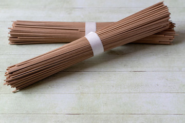 Japanese soba noodles on green wooden background 