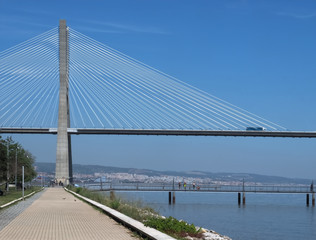 Walking the footpath Passeio do Tejo along Tagus river in Lisbon at the Expo park - Vasco da Gama bridge