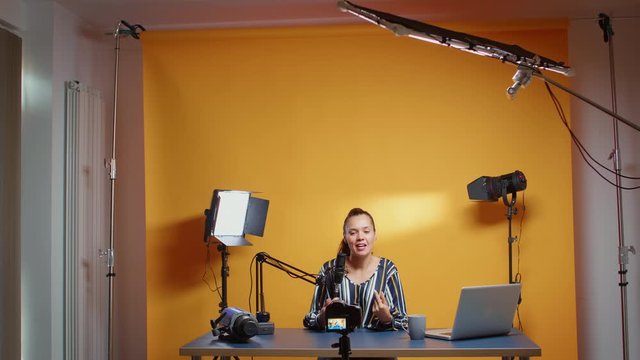 Influencer in her professional studio recording a new episode for subscribers. Backstage of content creator new media star on social media for internet web online audience podcast episode microphone