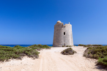 Fototapeta na wymiar Beautiful view of the old observation tower Torre De Ses Portes on the coast of the Ibiza island.